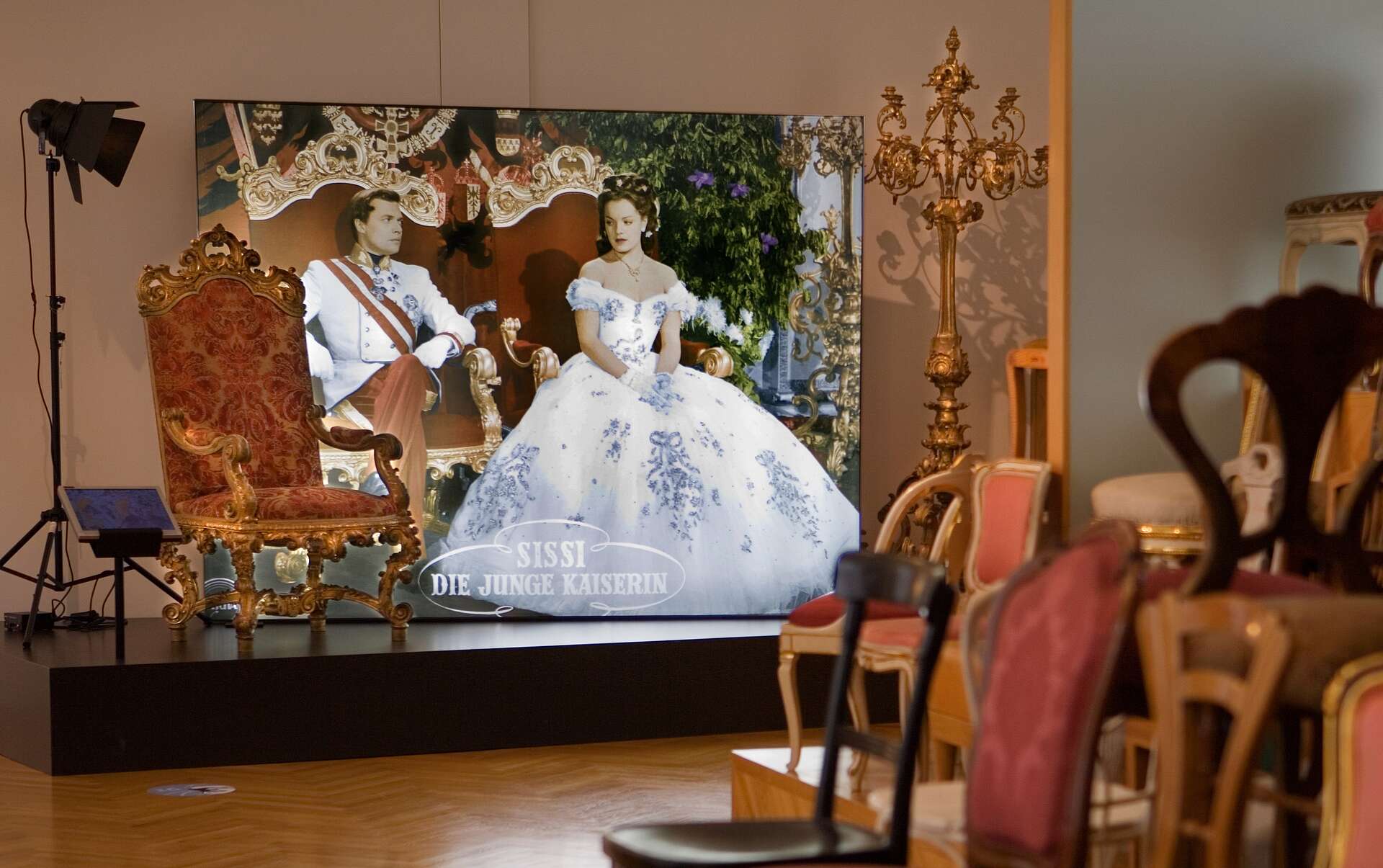 Projektion der Thronszene aus den Sissi Filmen, rechts stehen ein paar Stühle