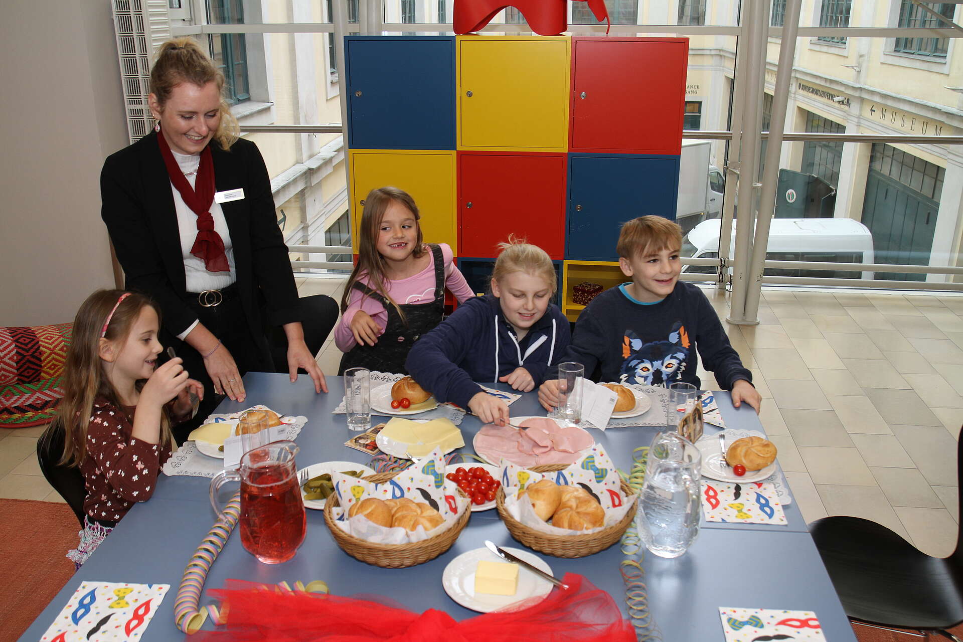 Kinder sitzen am Esstisch und genießen ein Jause